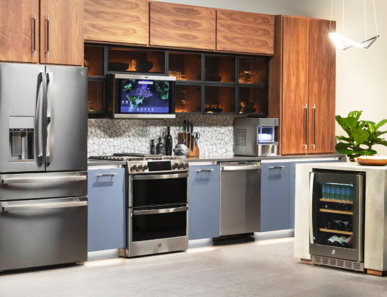 Stainless steel fridge, range and dishwasher in modern kitchen with dark wood cabinets